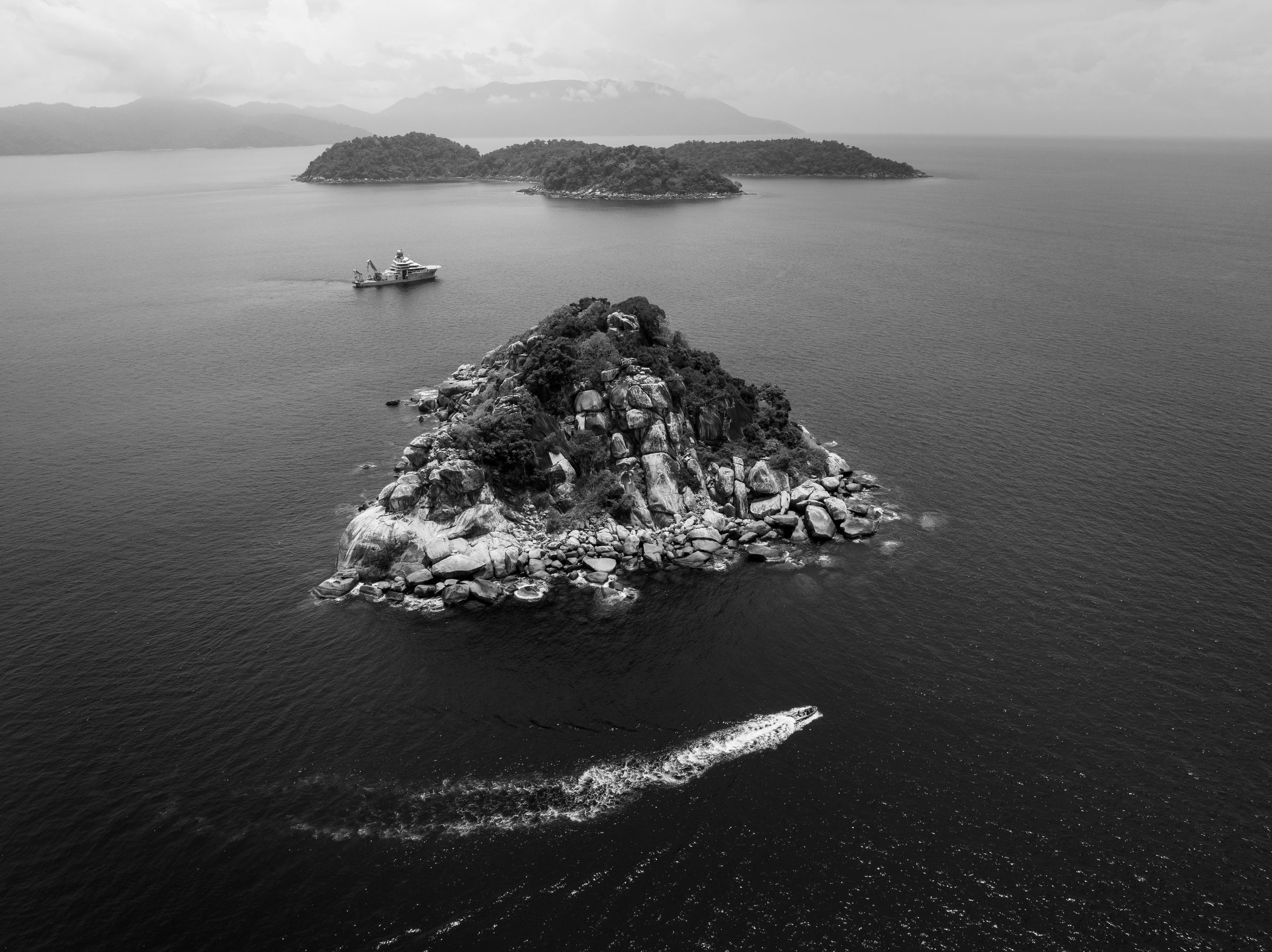 Aerial view of rocky islands with a vessel underway