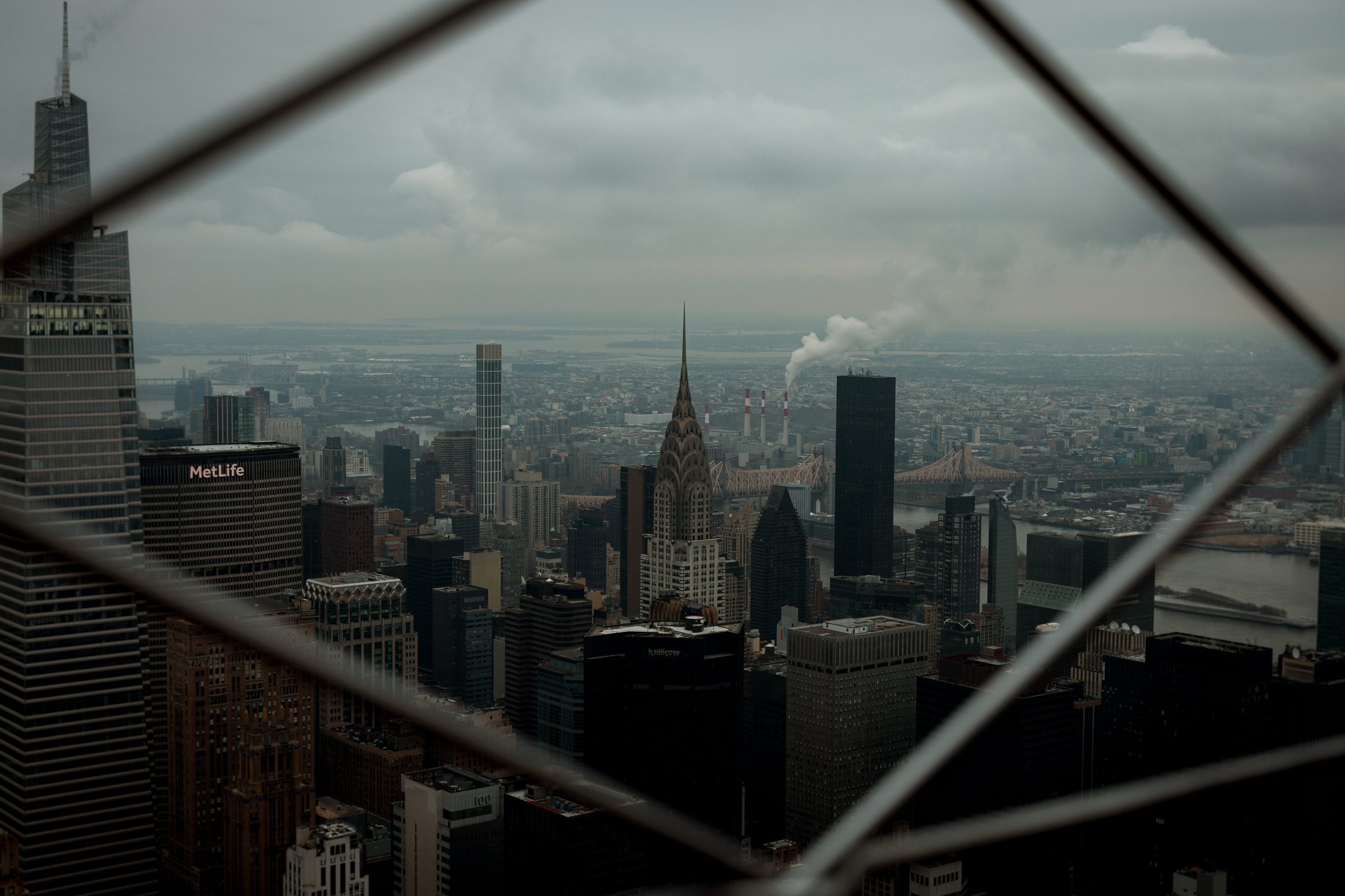 Manhattan skyline seen through an observation deck's protective cage