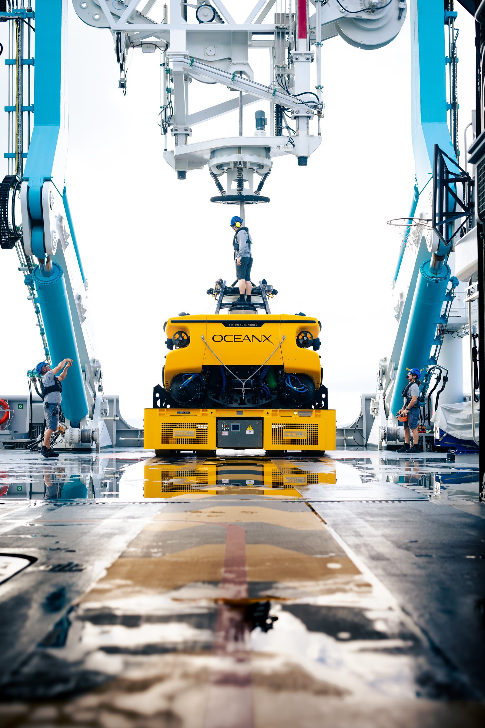 OceanX submersible being lifted by deck crane